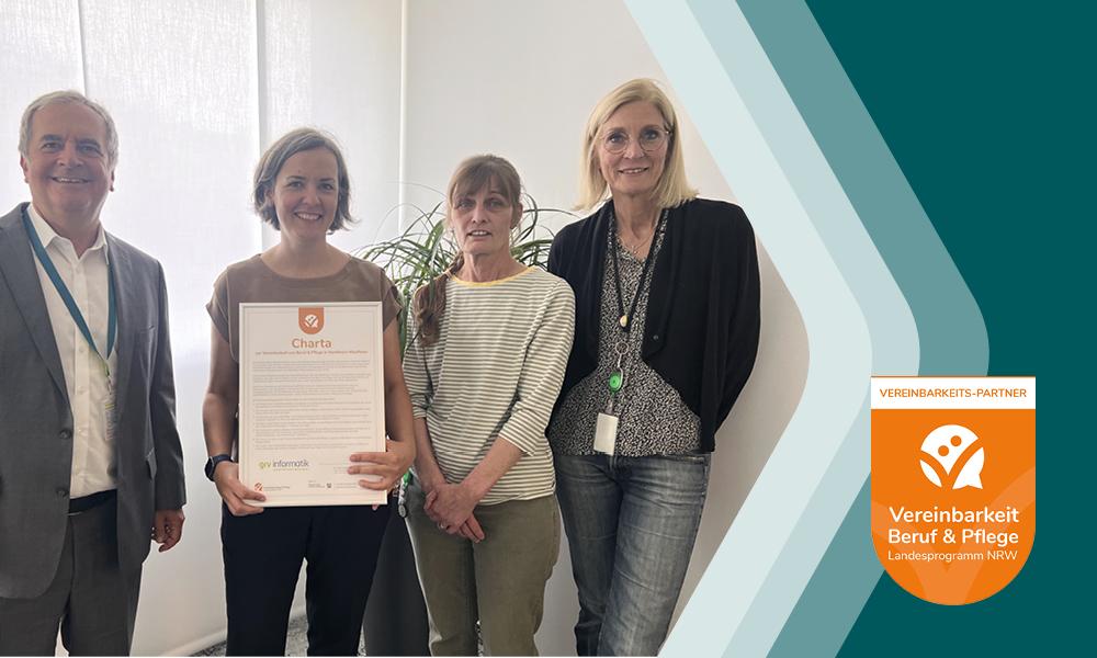 Das Bild zeigt vier Personen, die ein Zertifikat der "Charta für Vereinbarkeit Beruf & Pflege" präsentieren. Von links nach rechts sind Ulrich Arnold, Katrin Valbert (mit der Urkunde), Bettina Rinke und Nicole Monke zu sehen. Rechts im Bild ist das Logo des Vereinsbarkeits-Partners für Beruf & Pflege, Landesprogramm NRW, abgebildet. Die Szene findet in einem hellen Raum mit weißen Jalousien und einer Pflanze im Hintergrund statt.